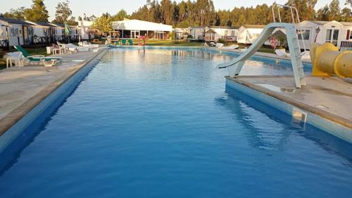 a swimming pool with a slide in the water at Bungalows 2XZ ou 327 in Burinhosa