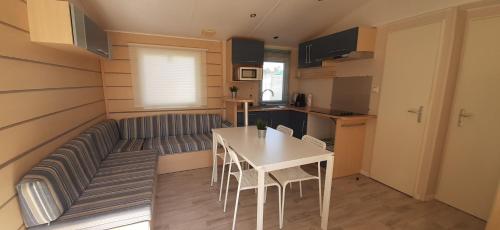 a small living room with a table and a couch at Bungalows 2XZ ou 327 in Burinhosa