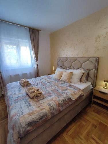 a bedroom with a large bed with towels on it at Golden dream apartman in Pančevo