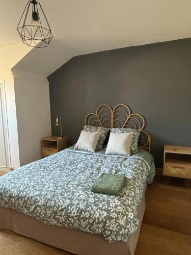 une chambre avec un grand lit avec une couverture bleue dans l'établissement Le cocon, à Aurillac