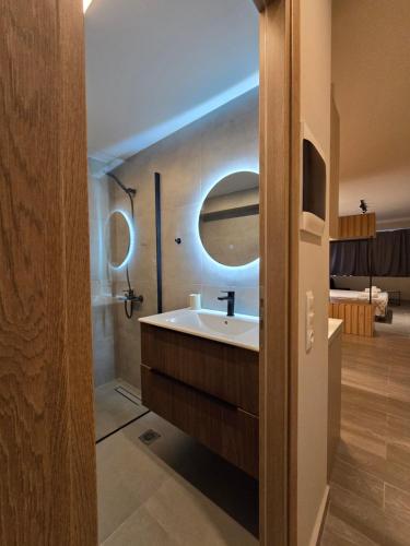 un baño con lavabo y espejo en Órrhaon Athens, en Atenas