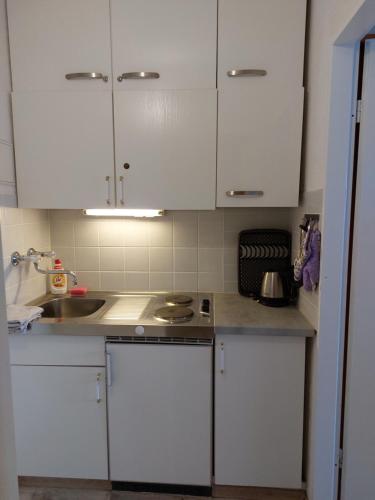 a kitchen with white cabinets and a sink at Apartment Almberg in Mitterfirmiansreut