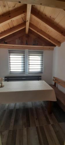 a room with a large bed in a room with two windows at Holiday Home Krejović in Žabljak