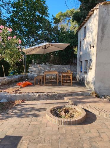 a patio with a table and an umbrella at La Rocca di Gagliole in Gagliole