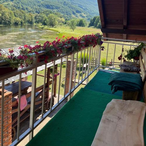 a balcony with flowers and a view of a river at Bed and Breakfast Family Djukic in Šipovo