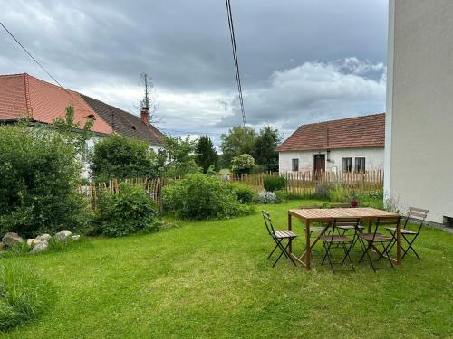 a table and chairs in the yard of a house at Apartmány Hodňov 17 in Horní Planá