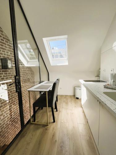 une cuisine avec une table et un mur en briques dans l'établissement villa Konny studio 1er étage, au Tréport