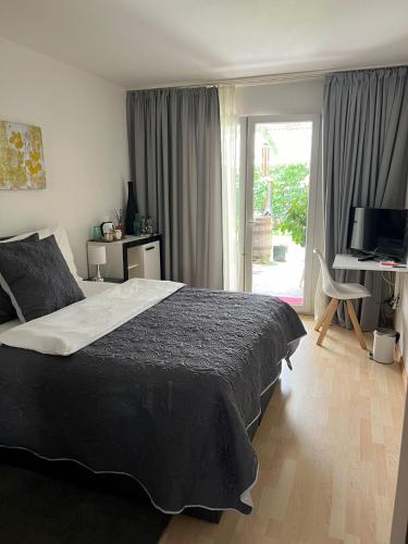 a bedroom with a bed and a desk and a window at Daianas Corner in Elgg
