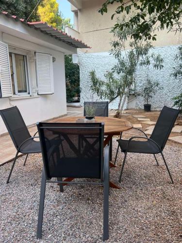 a wooden table and two chairs and a table and chairs at Studio next to the Beach in Vouliagmeni