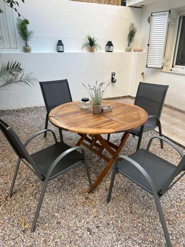 a wooden table with two chairs and a table with a drink at Studio next to the Beach in Vouliagmeni