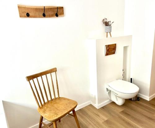 een badkamer met een toilet en een houten stoel bij Vadrózsa apartman in Badacsonytomaj