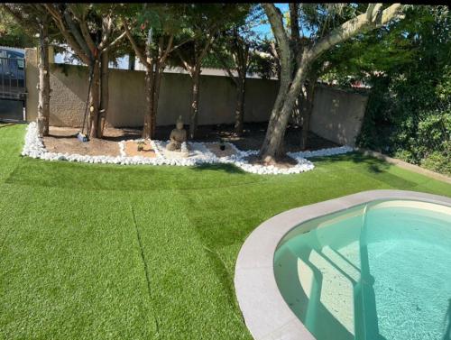 a yard with a swimming pool and trees and a fence at Studio jacuzzi à l'abri des vents in Carcassonne