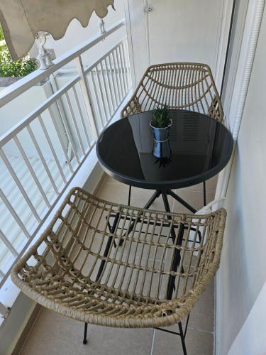 a black table and chairs on a balcony at Maggie's Blissful Escape in Loutraki