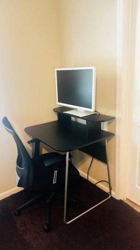 a desk with a computer monitor and a chair at Cozy home with BBQ -5 min Braves in Atlanta