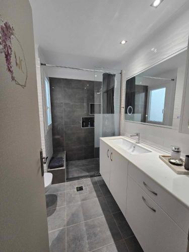 a bathroom with a sink and a toilet and a shower at Maggie's Blissful Escape in Loutraki