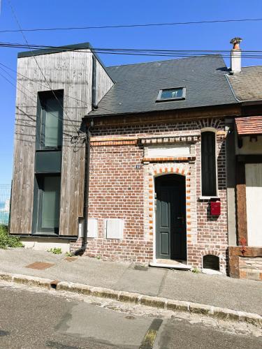 une vieille maison en briques avec une porte noire dans une rue dans l'établissement villa Konny studio rez-de-chaussée, au Tréport