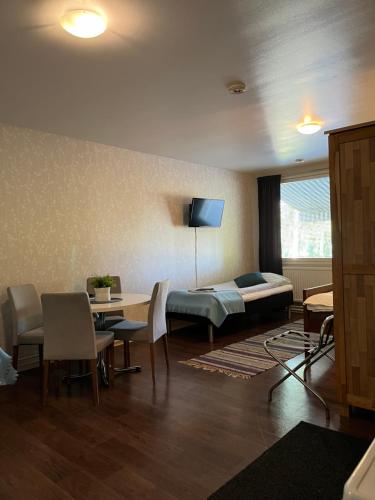 a living room with a bed and a table and chairs at Hotelli Keskipiste in Kärsämäki