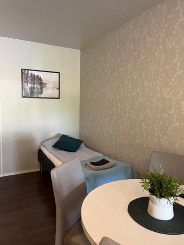a room with a bed and a table and chairs at Hotelli Keskipiste in Kärsämäki