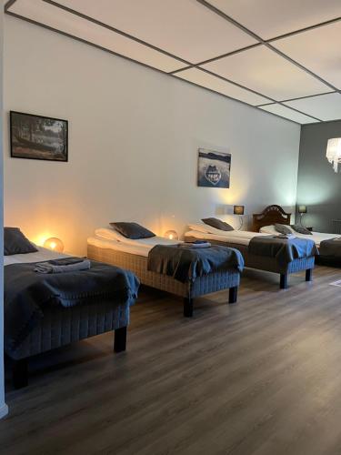a room with three beds in a room at Hotelli Keskipiste in Kärsämäki