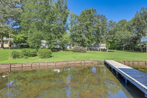 a wooden bridge over a pond in a park at Lakefront Milledgeville Home with Private Dock! in Resseaus Crossroads