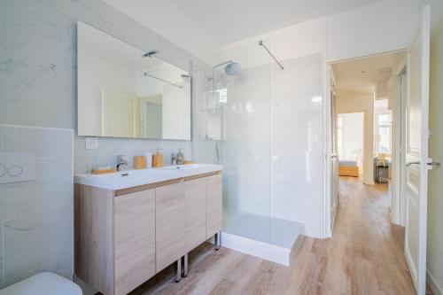une salle de bain blanche avec un lavabo et une douche dans l'établissement Le Castellane coeur centre ville, à Marseille
