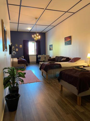 a bedroom with two beds and a living room at Hotelli Keskipiste in Kärsämäki