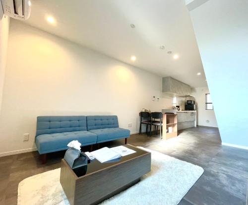 a living room with a blue couch and a table at New三軒茶屋ハウス 渋谷まで電車5分 三軒茶屋駅徒歩6分 2023年フルリノベ戸建 in Tokyo