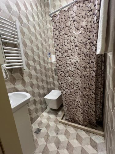 a bathroom with a toilet and a stone wall at Laguna apartment in Tivat