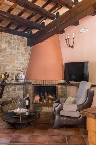 a living room with a fireplace and a tv at Cal Carulla in L'Astor