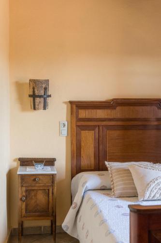 a bedroom with a wooden bed and a night stand at Cal Carulla in L'Astor