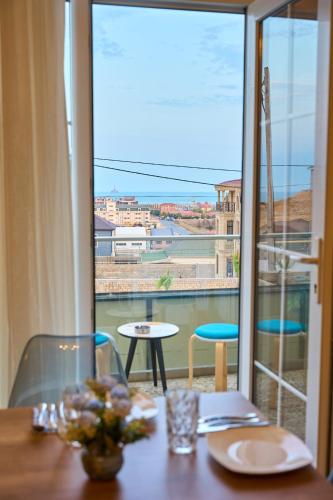 a dining table with a view of a balcony at Premium Sea View Hotel & Hostel in Baku
