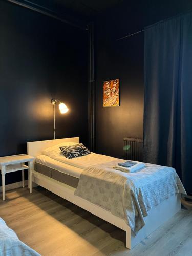a bedroom with a bed and a table and a lamp at Hotelli Keskipiste in Kärsämäki