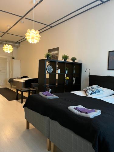 a bedroom with a large bed and a living room at Hotelli Keskipiste in Kärsämäki