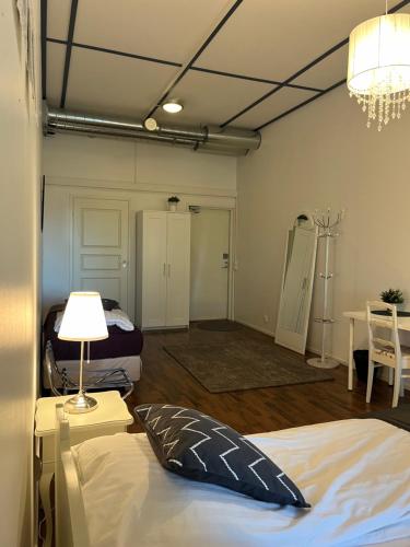 a room with two beds and a lamp and a table at Hotelli Keskipiste in Kärsämäki