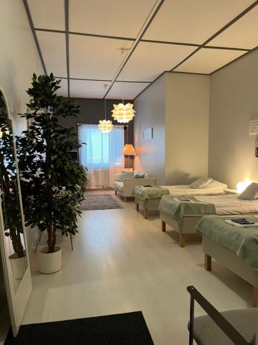 a hospital room with four beds and a potted plant at Hotelli Keskipiste in Kärsämäki