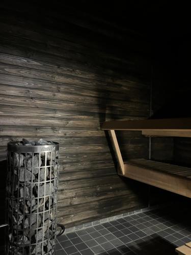 a trash can in a room with a wooden wall at Hotelli Keskipiste in Kärsämäki