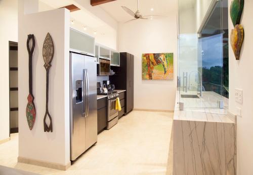 a kitchen with a stainless steel refrigerator in a room at Ocean View Villa With Pool and Spectacular Sunsets in Ballena