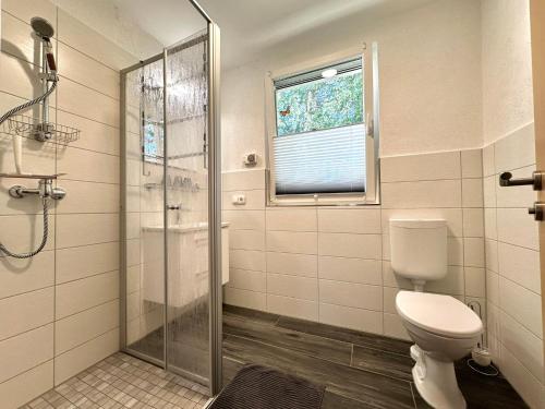 a bathroom with a toilet and a glass shower at Tornower Waldhäusl, perfekt gelegen 60 km vor Berlin, auf der Schwelle zum Spreewald und nahe Tropical Islands in Tornow