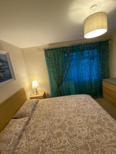 a bedroom with a bed and a window with blue curtains at Gala House in Lurgan