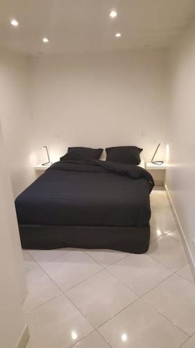 - une chambre dotée d'un lit noir avec deux lumières dans l'établissement Maison aéroport de Paris, à Le Thillay