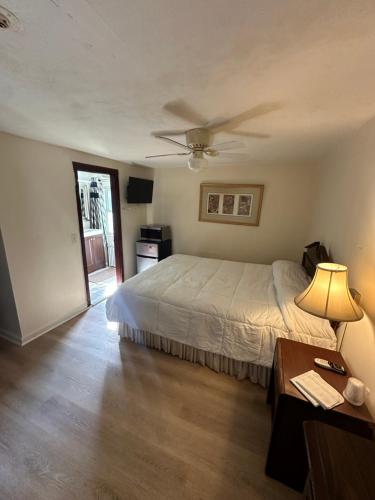 a bedroom with a bed and a table with a lamp at Gaard motel in Foxborough