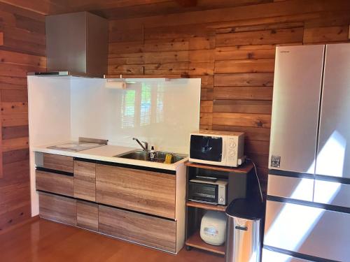 a kitchen with a sink and a refrigerator at Hakuba Brownie Cottages in Hakuba