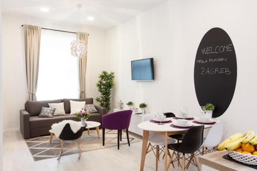 a living room with a couch and a table and chairs at Tesla Boutique Apartments & Rooms in Zagreb