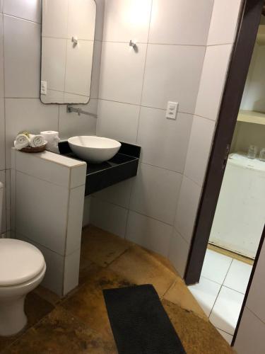a bathroom with a sink and a toilet and a mirror at Pousada Vila Canoa in Canoa Quebrada