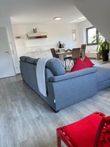 a bedroom with a blue bed and a living room at LUX Ferienwohnungen in Hepbach