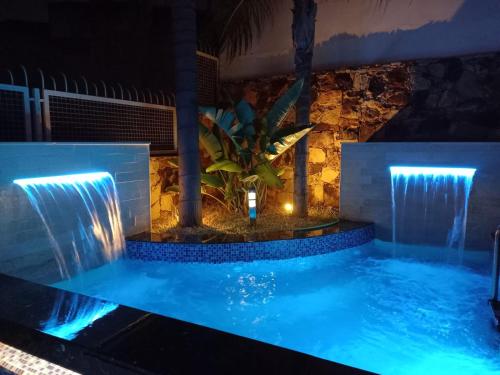 a swimming pool with two waterfalls in a room at Villa belle lune in Ariana