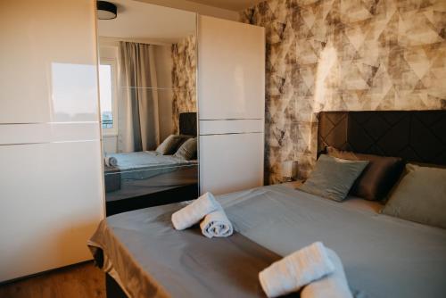 a bedroom with a bed with two towels on it at Tara View Apartment in Subotica