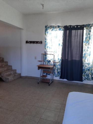 a room with a bed and a window and a table at Casita con vista a las montañas in Tepoztlán