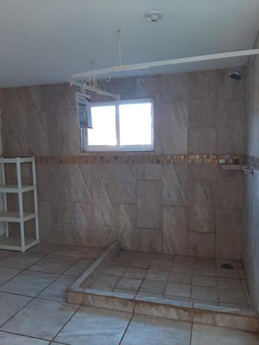 a bathroom with a tiled floor and a window at Casita con vista a las montañas in Tepoztlán