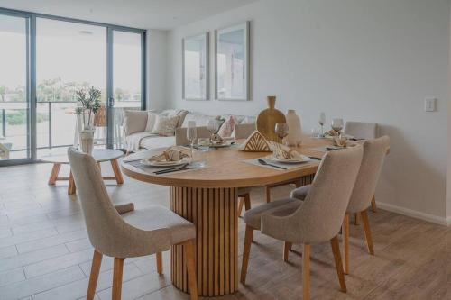 a living room with a wooden table and chairs at Lux Lakeside Apt - Gold Coast in Gold Coast